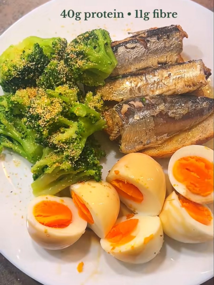 Plate of halved boiled eggs, sardines on buttered sourdough and a pile of broccoli
