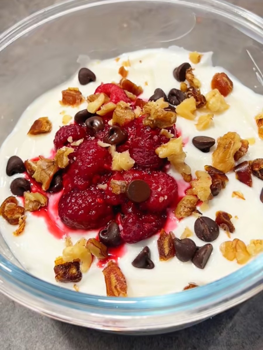 Greek yoghurt over a wheat biscuit base, topped with raspberries, dark chocolate chips, chopped dates and walnuts